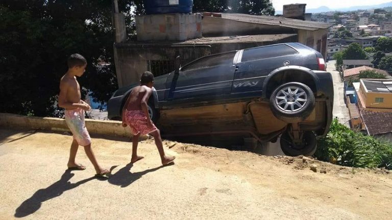 Motorista perde controle em ladeira e carro fica pendurado em casa