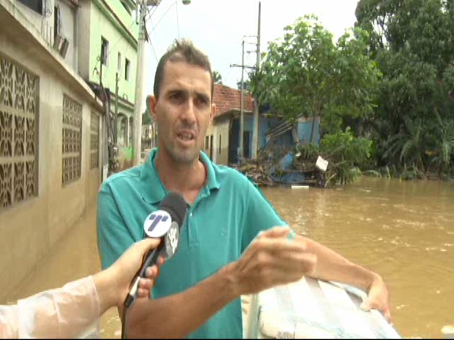 Voluntários levam alimentos de barco à desabrigados da enchente em Cariacica